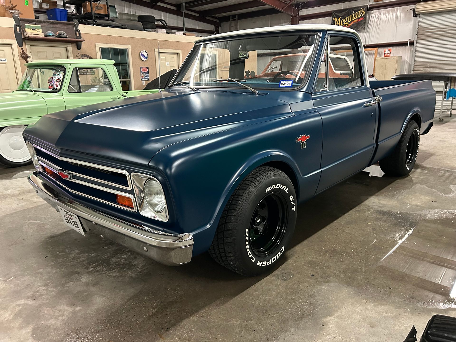 Blue vintage Chevy pickup truck in a garage.