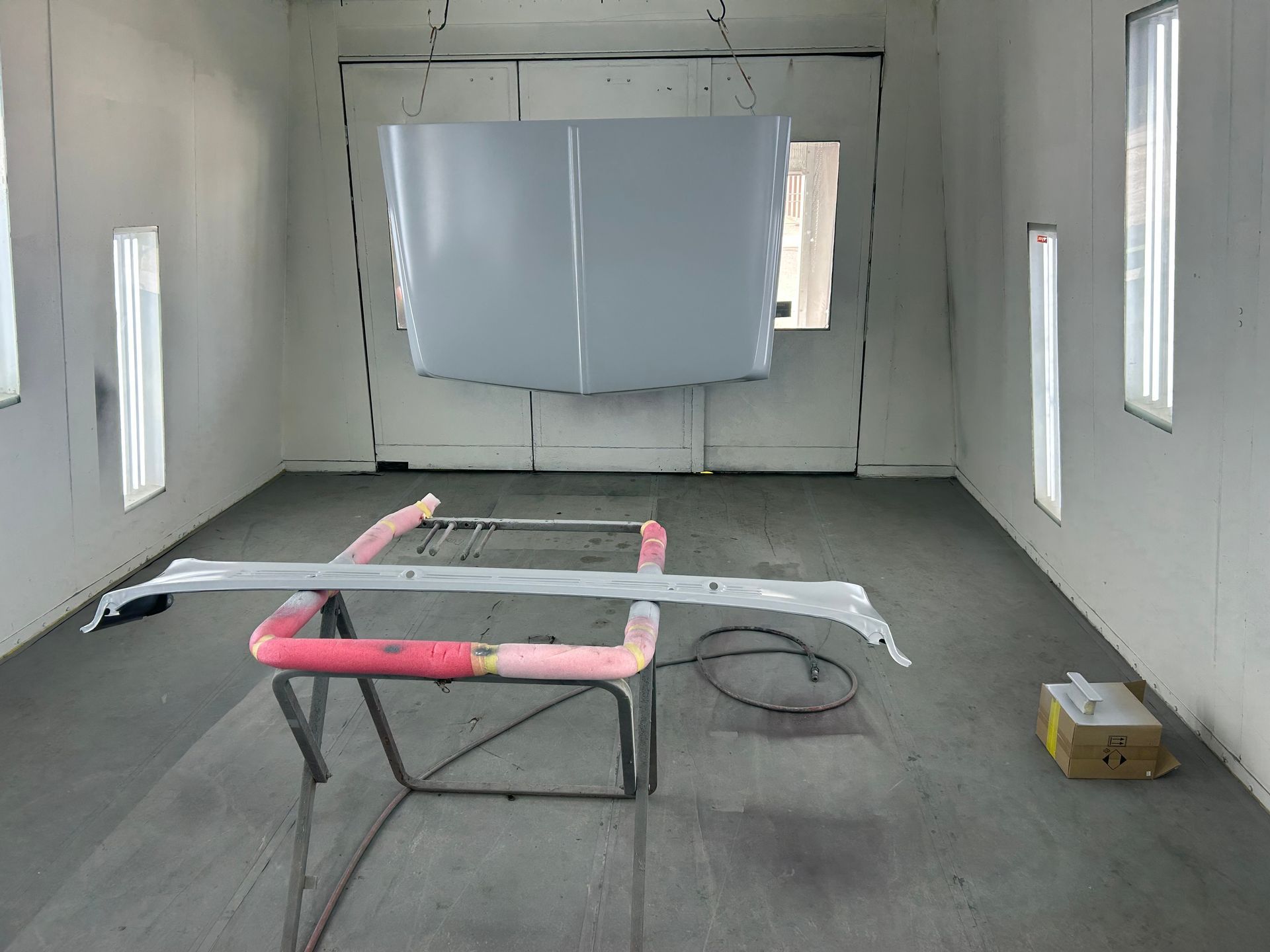 Car hood and bumper freshly painted in a spray booth.