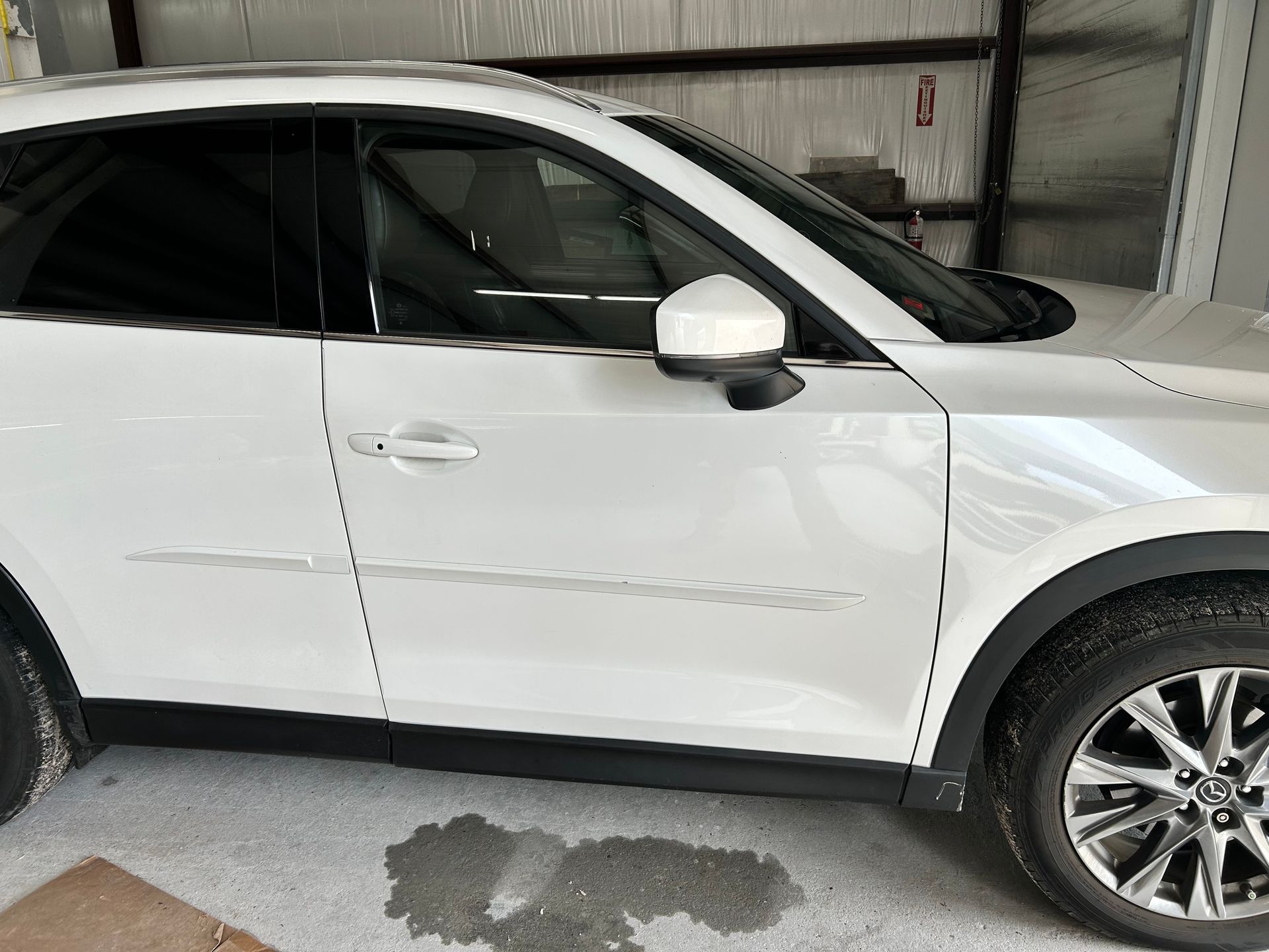 White SUV parked inside a garage. Black trim and tinted windows are visible.