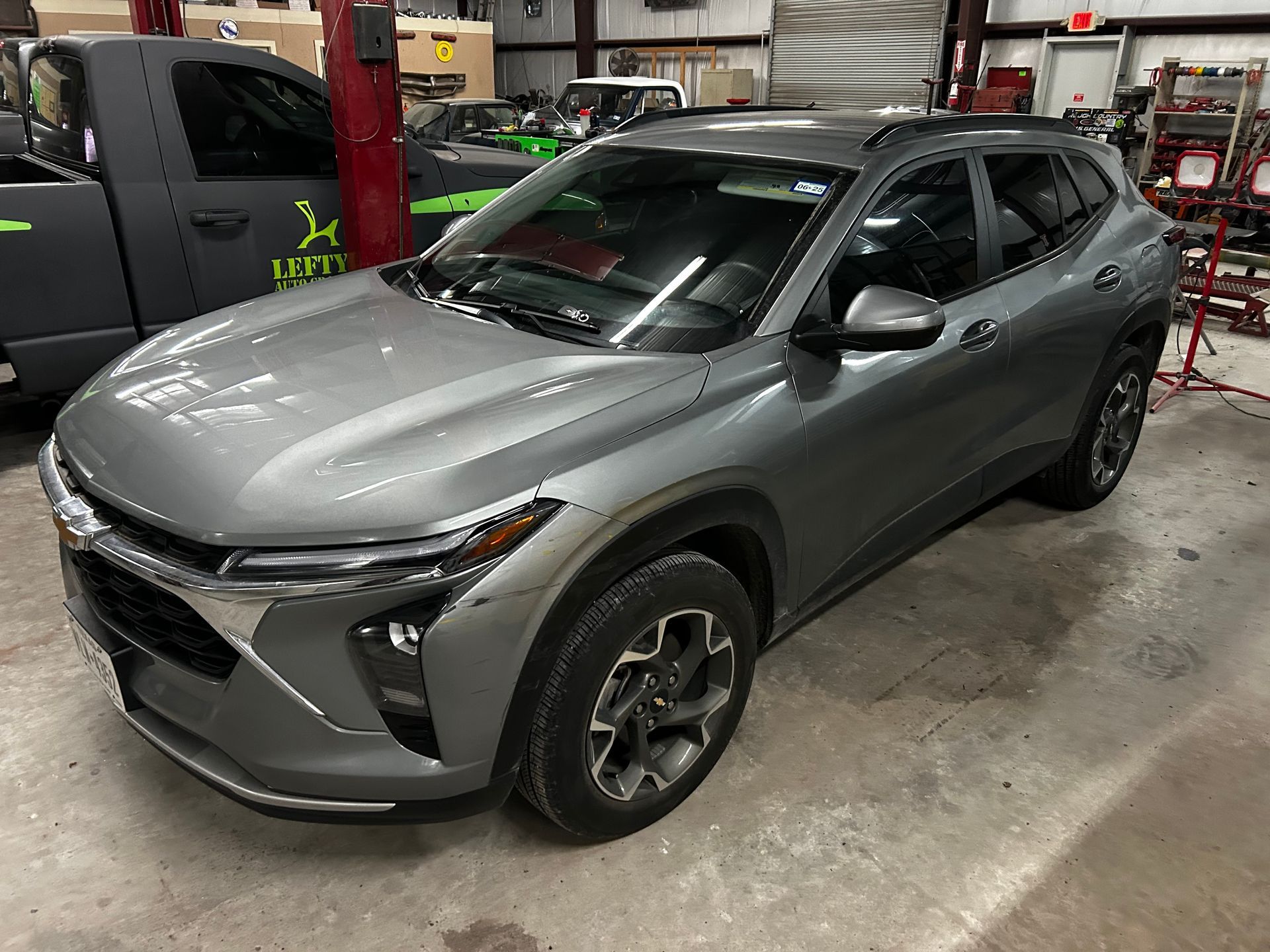 Gray Chevy Trax SUV parked inside a shop.