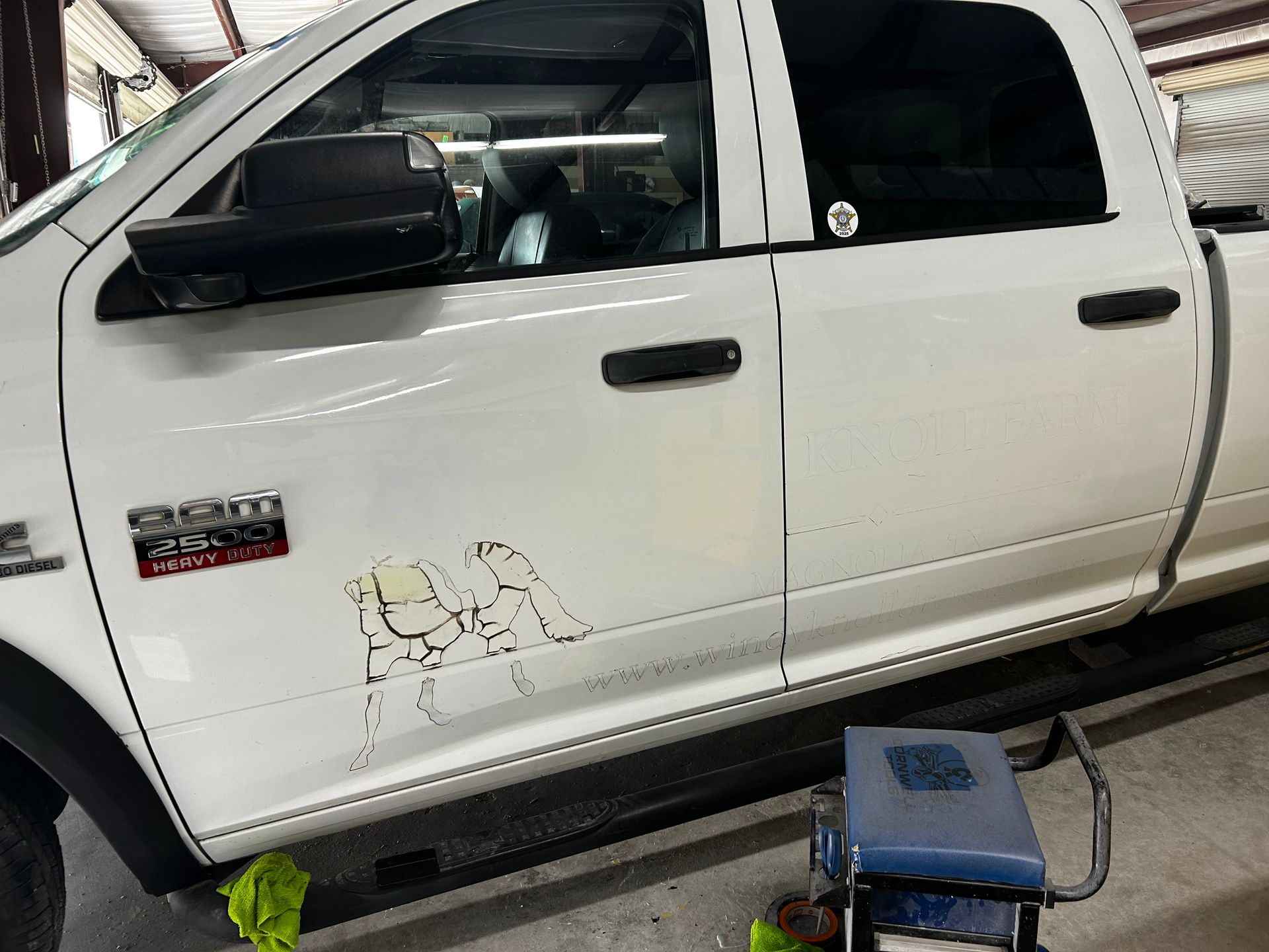 White Ram pickup truck with cartoon-like decal on the door in a garage setting.