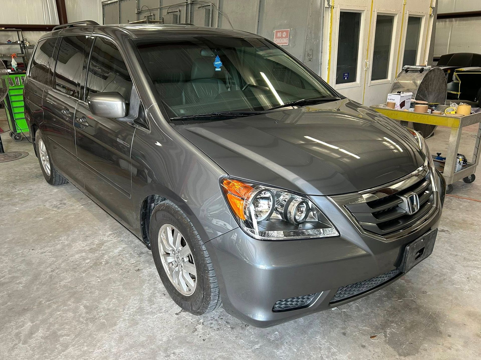 Gray Honda Odyssey minivan in a garage.