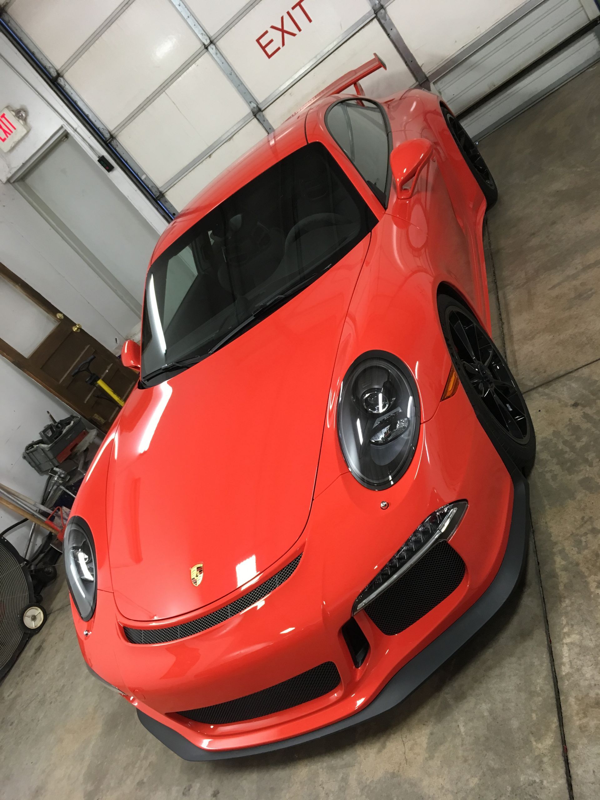 Bright orange Porsche 911 GT3 inside a garage with an 