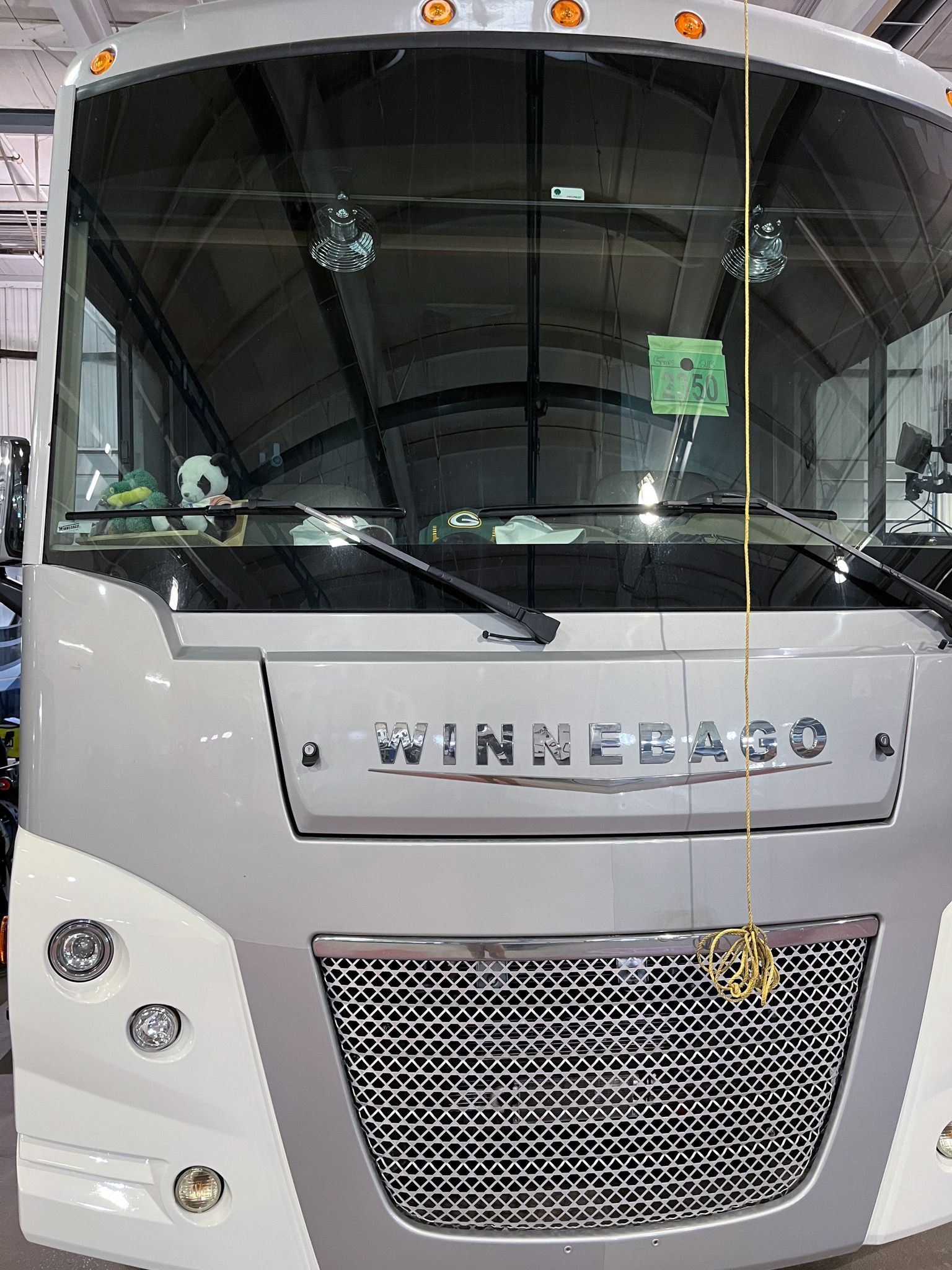 Silver Winnebago RV front view, grill, headlights, and large windshield, with the 