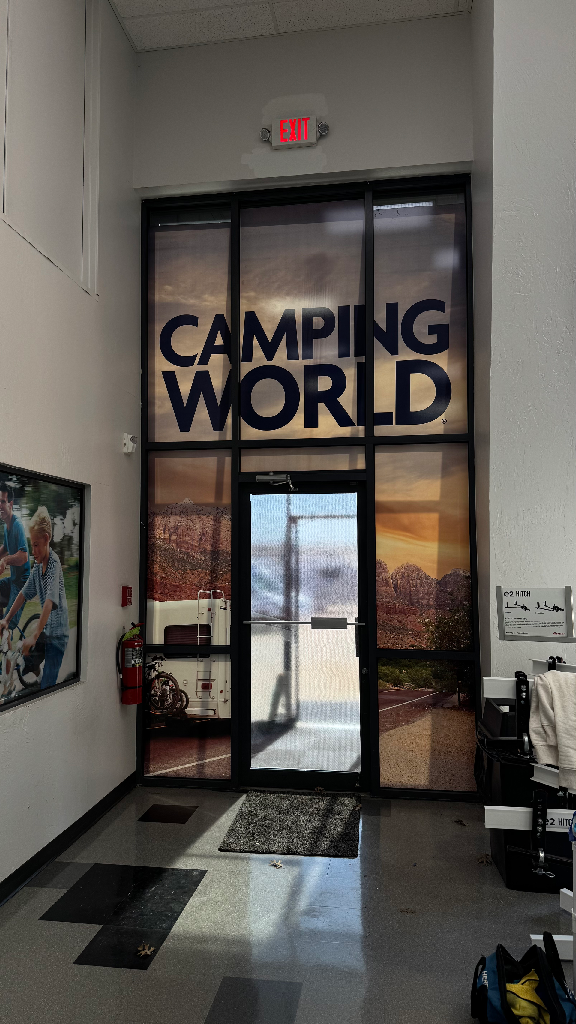 Entrance to Camping World with large text on windows, featuring outdoor scene.