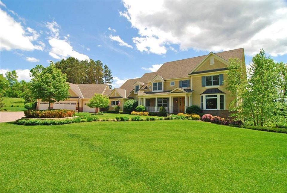 A large house with a lush green lawn in front of it