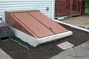 A brown door is sitting on the side of a house next to a hose.