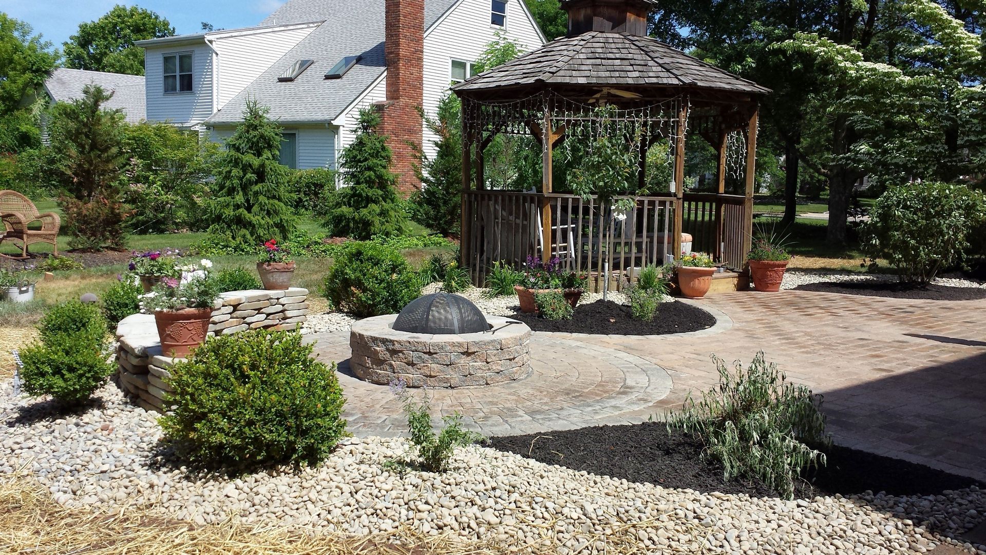 A gazebo is sitting in the middle of a lush green garden.