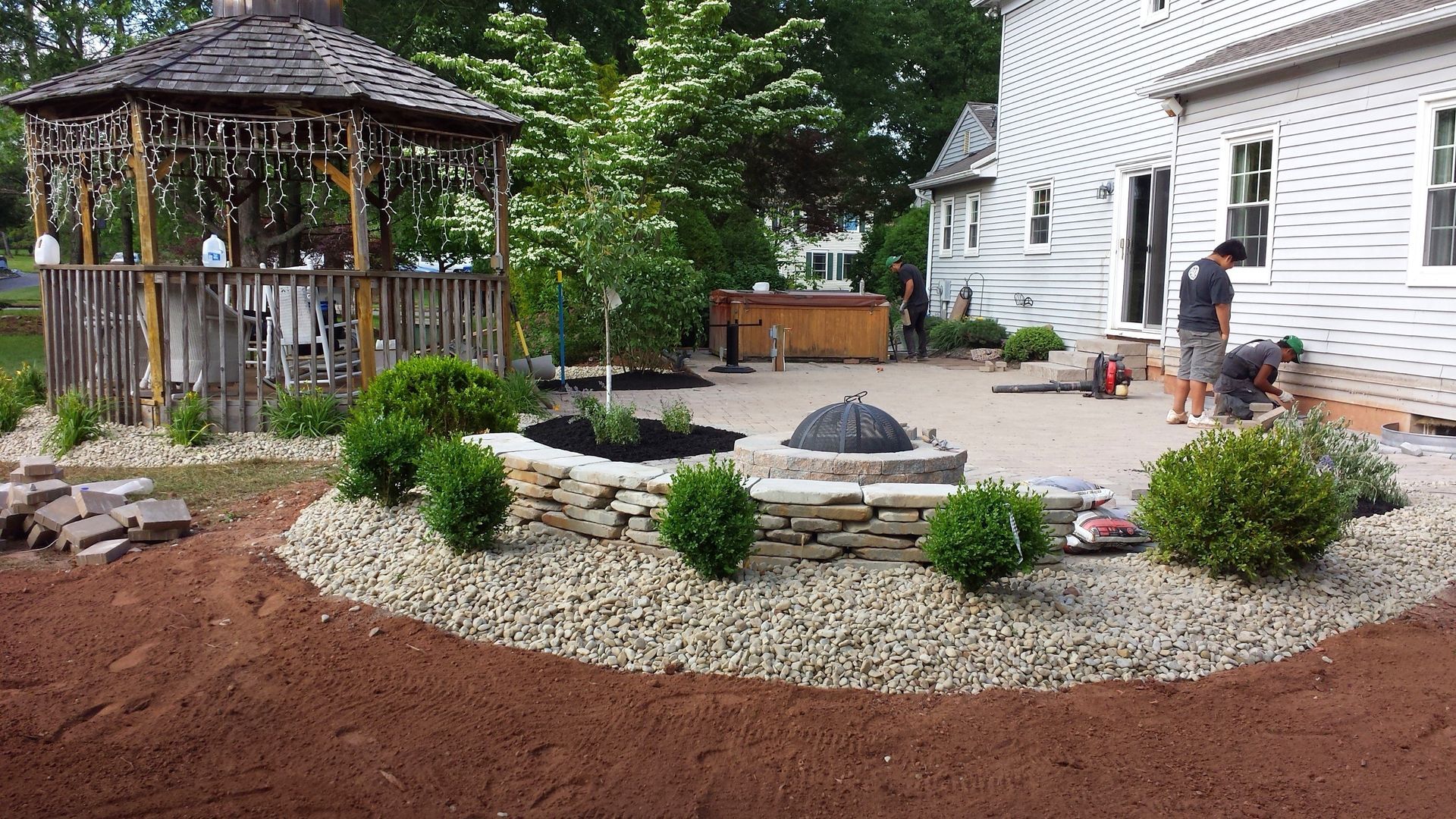 A gazebo is being built in the backyard of a house.