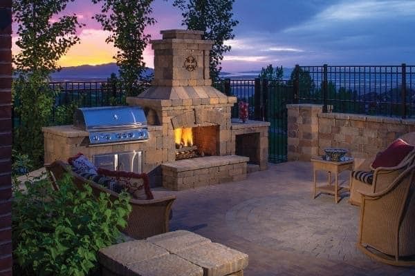A patio with a fireplace and a grill