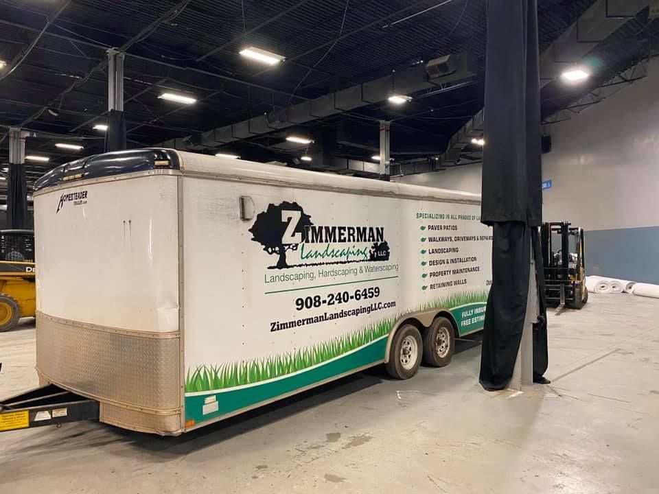 A trailer is parked in a warehouse next to a forklift.