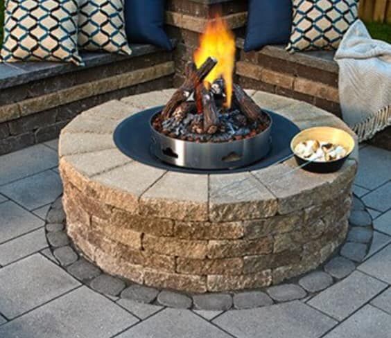 A fire pit with a bowl of marshmallows next to it