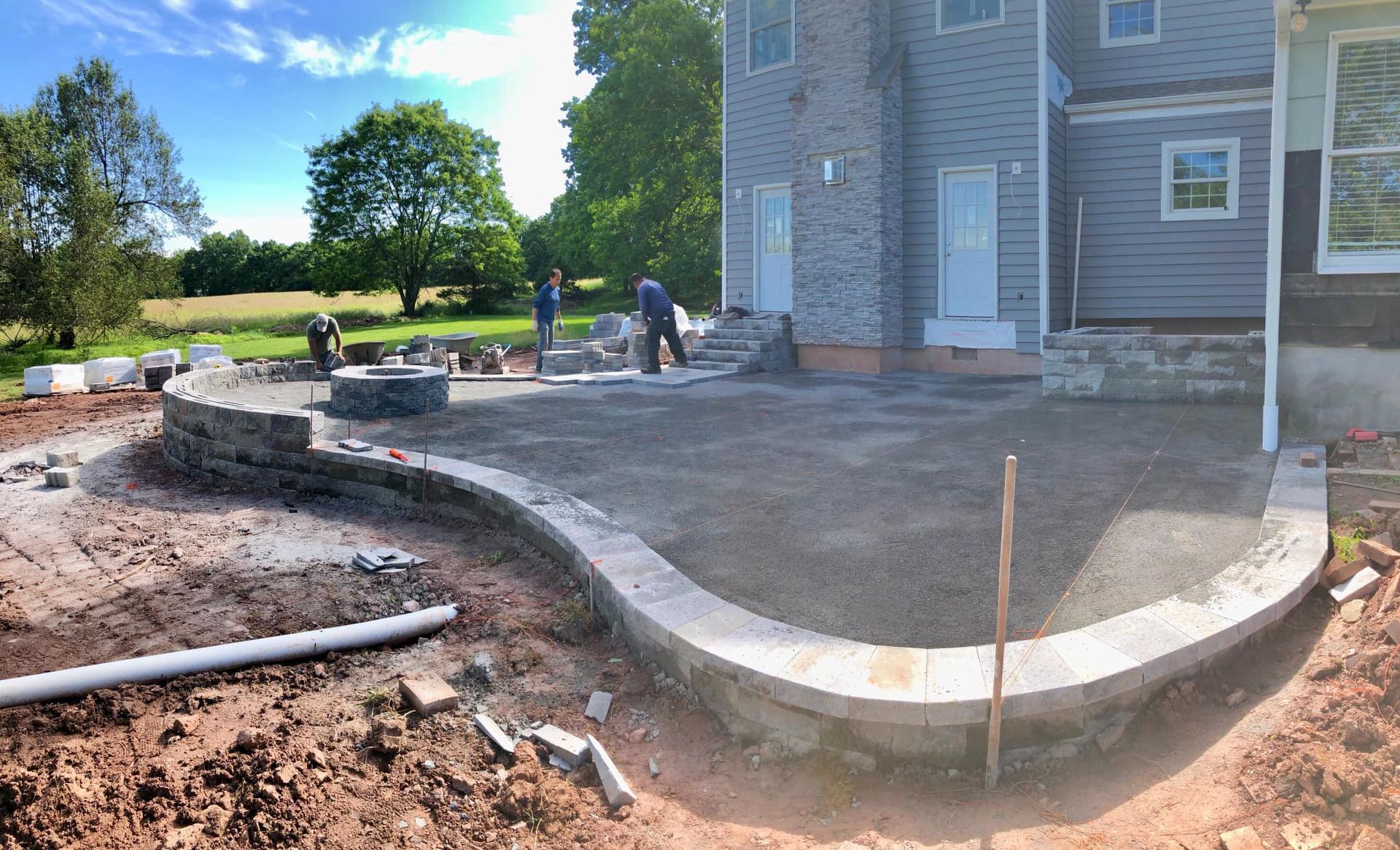 A patio is being built in front of a house.