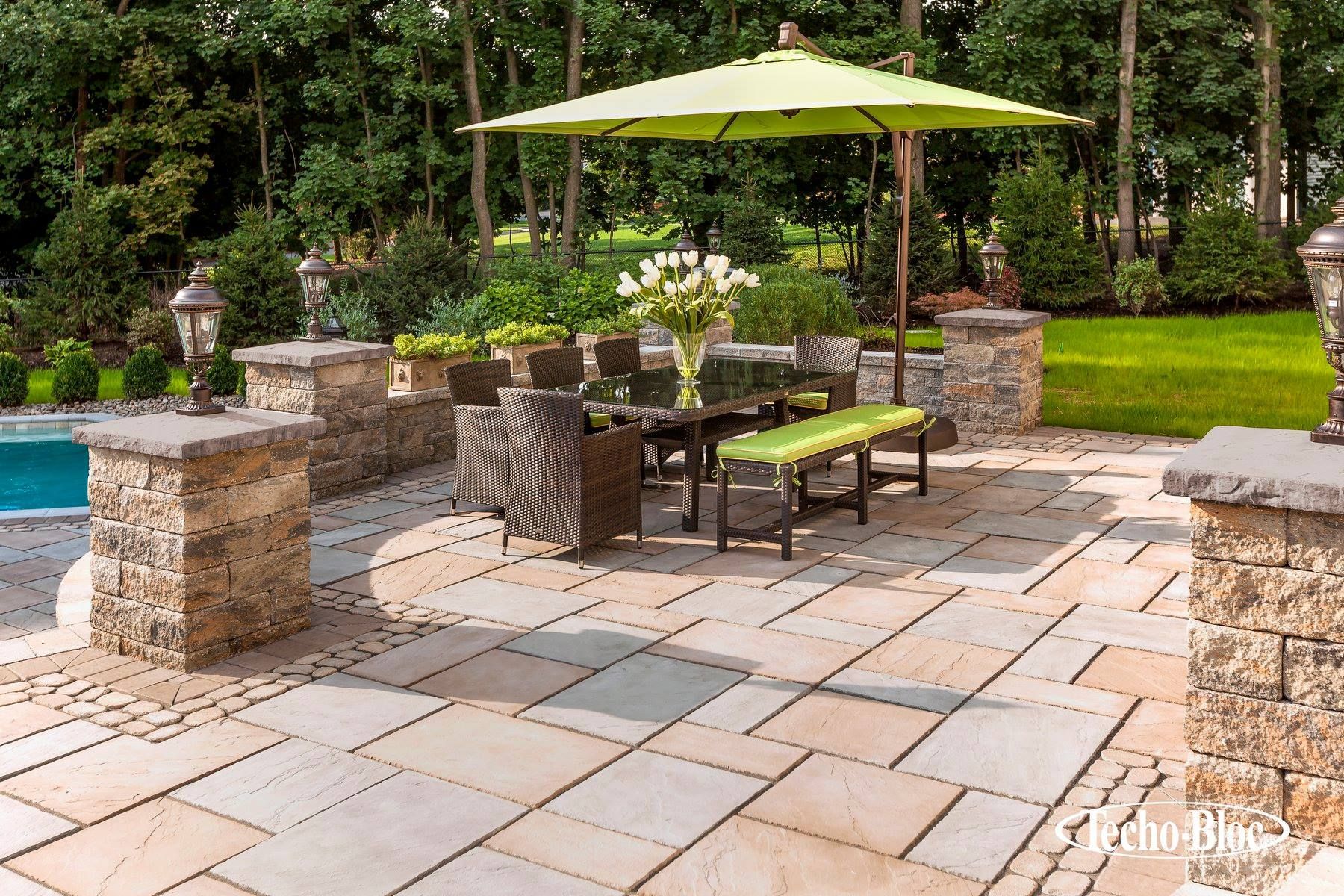 A patio with a table and chairs and a green umbrella.