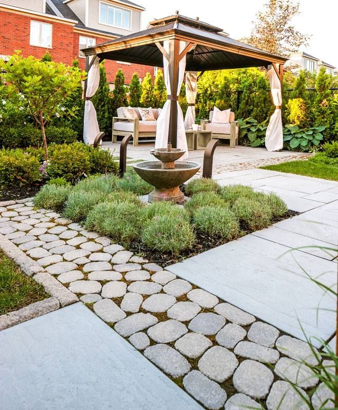 A patio with a gazebo and a fountain in the middle