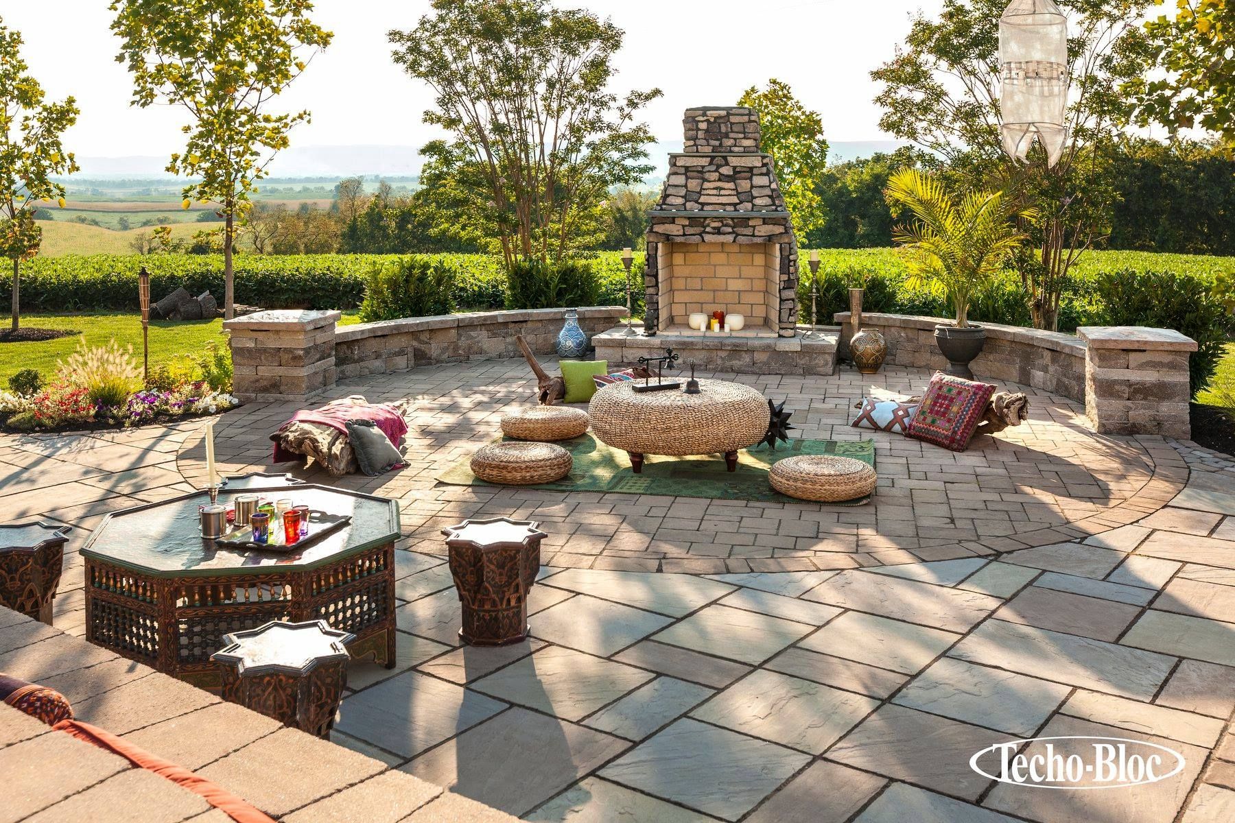 A patio with a fireplace and a table and chairs