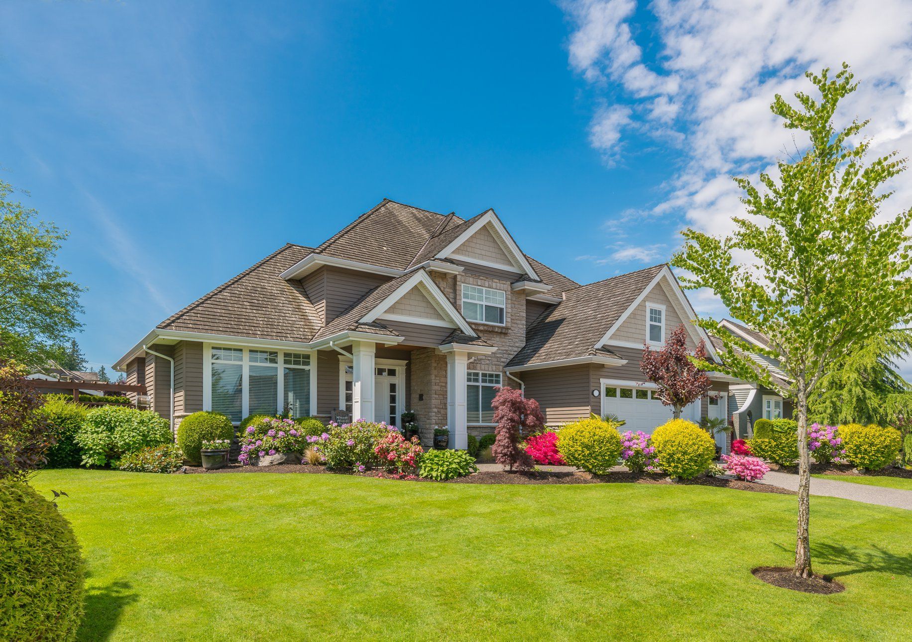 A large house with a lush green lawn in front of it.