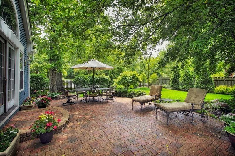 There is a patio with a table and chairs and an umbrella.