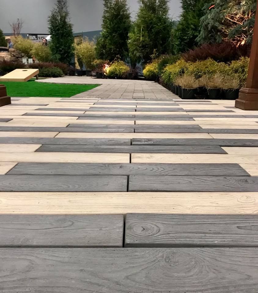 A row of wooden steps leading up to a lush green garden.