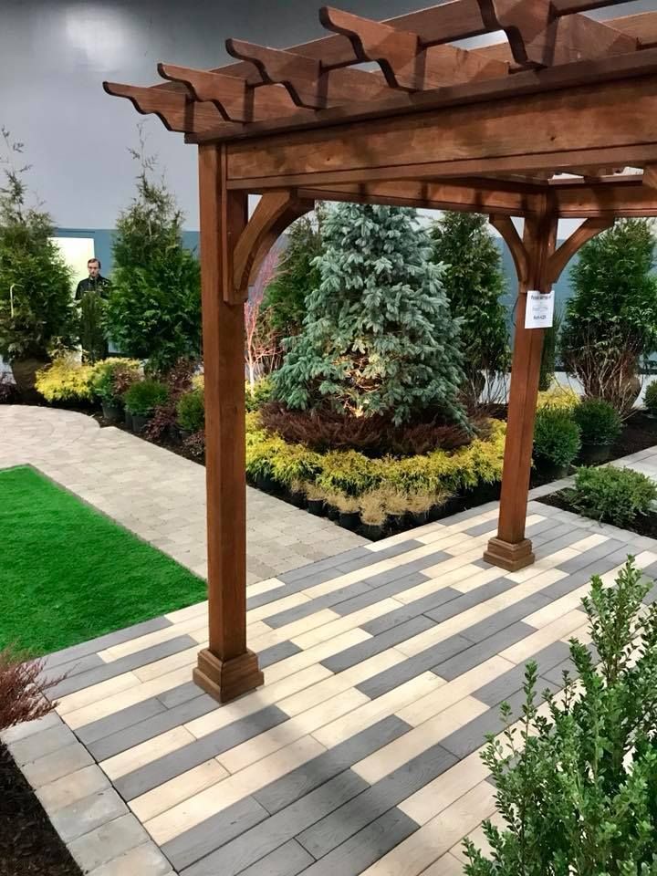 There is a wooden pergola in the middle of a garden.