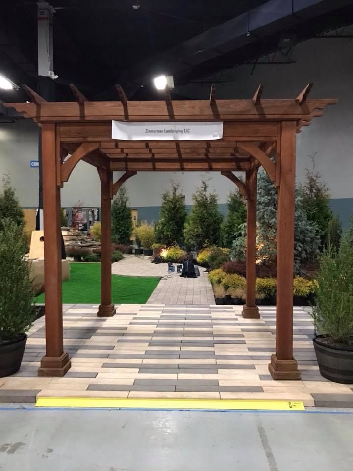 A wooden pergola is sitting in the middle of a room.