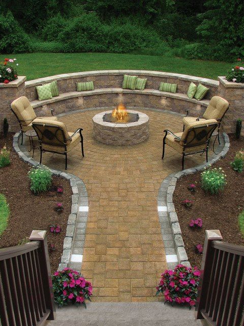 There is a fire pit in the middle of the patio surrounded by chairs.