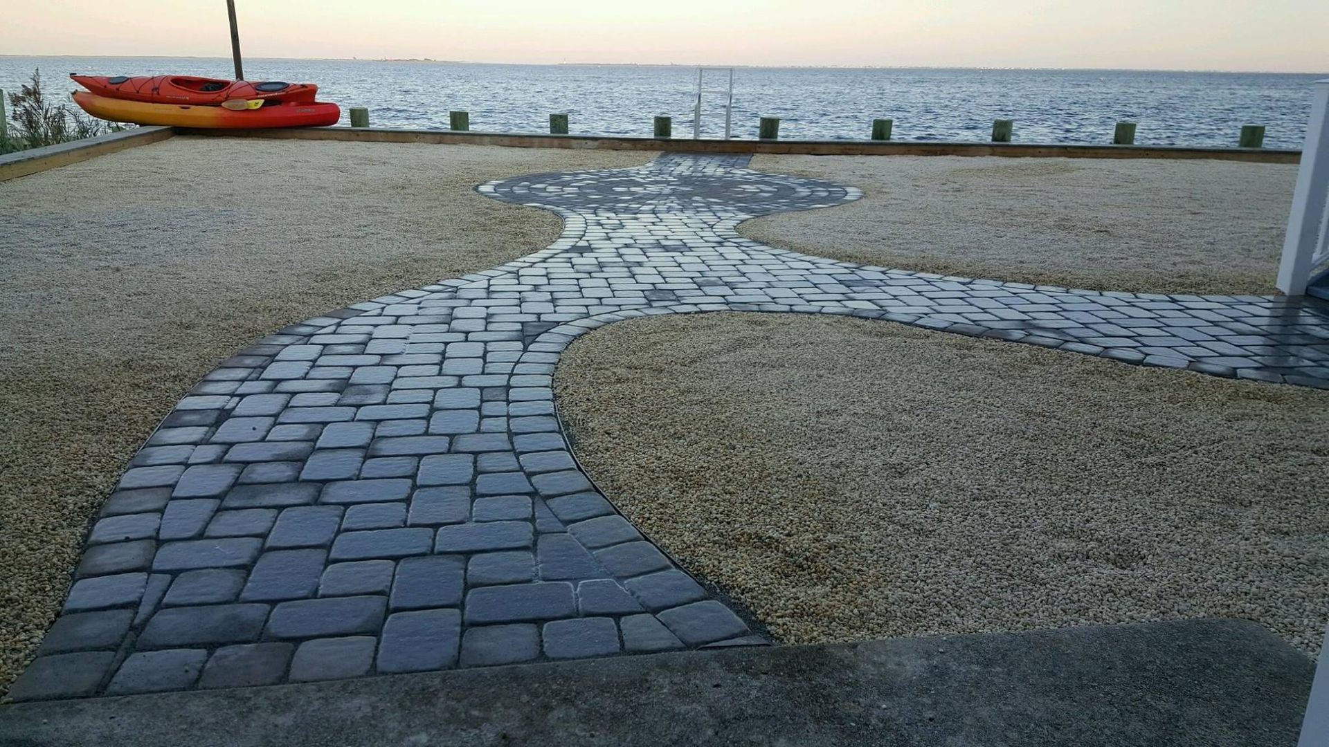 A path leading to the ocean with a kayak in the background
