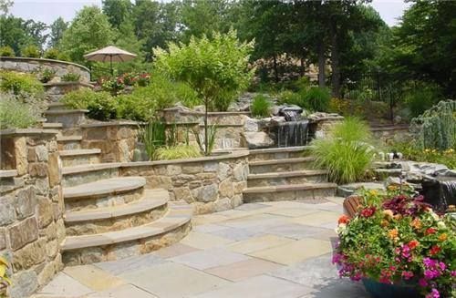 A patio with stairs and a waterfall in the background
