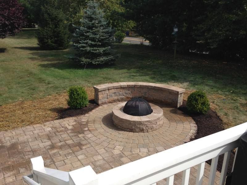 A fire pit in the middle of a patio with a white railing