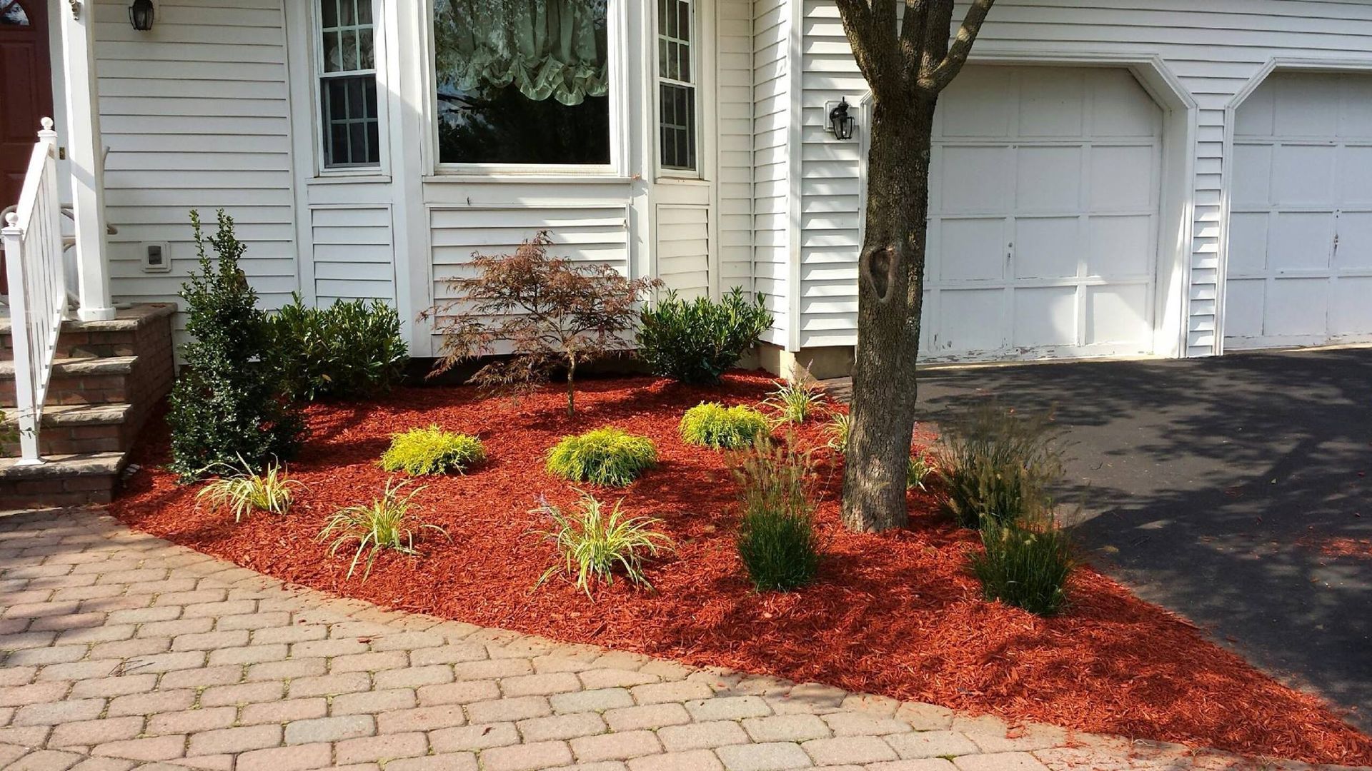 A white house with red mulch in front of it
