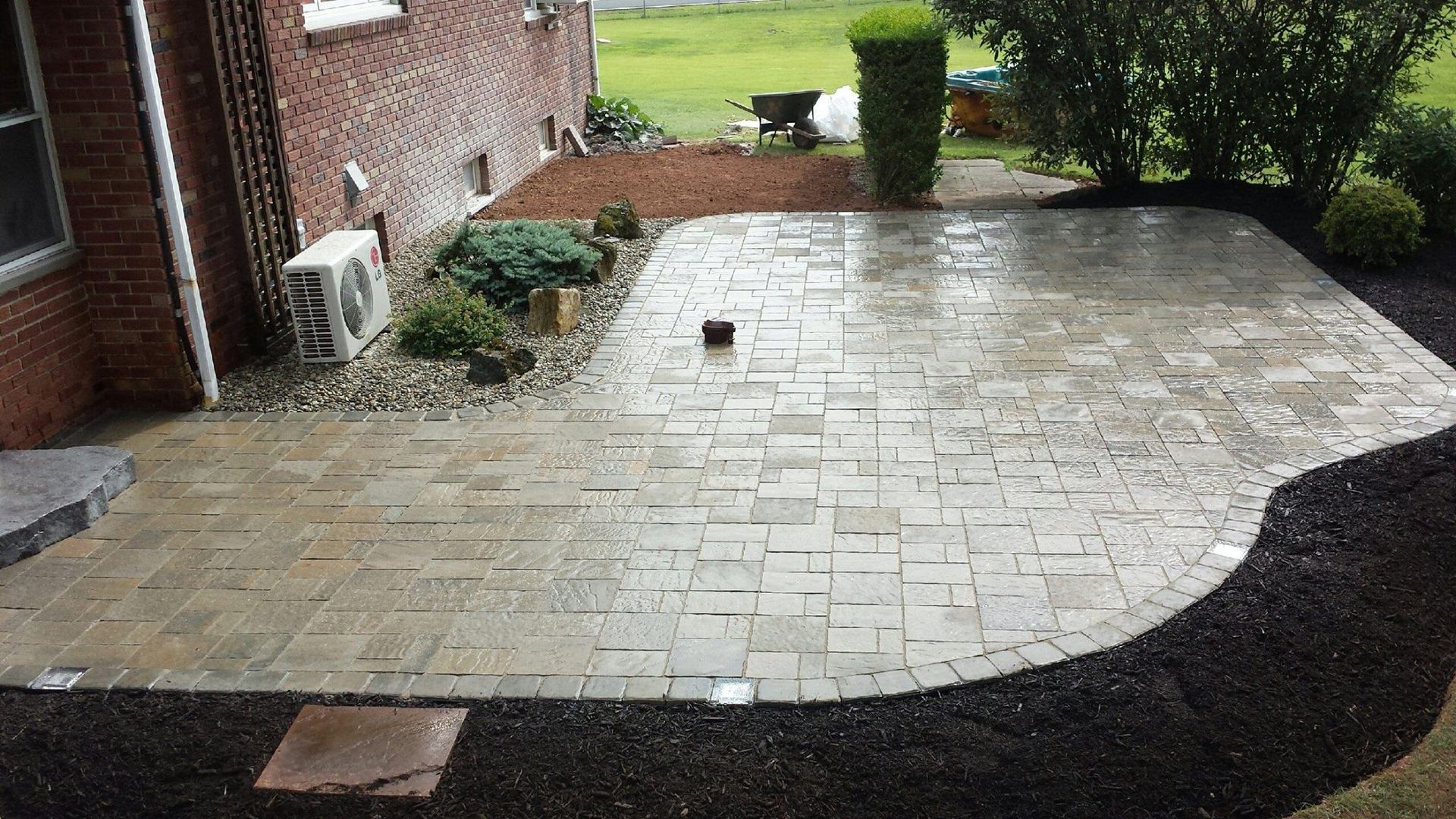 A brick patio is being built in front of a brick house.
