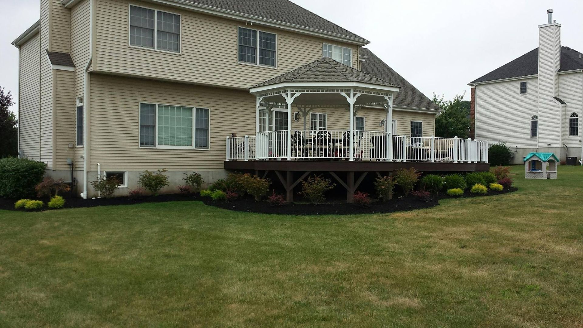 A large house with a large deck and gazebo in the backyard.