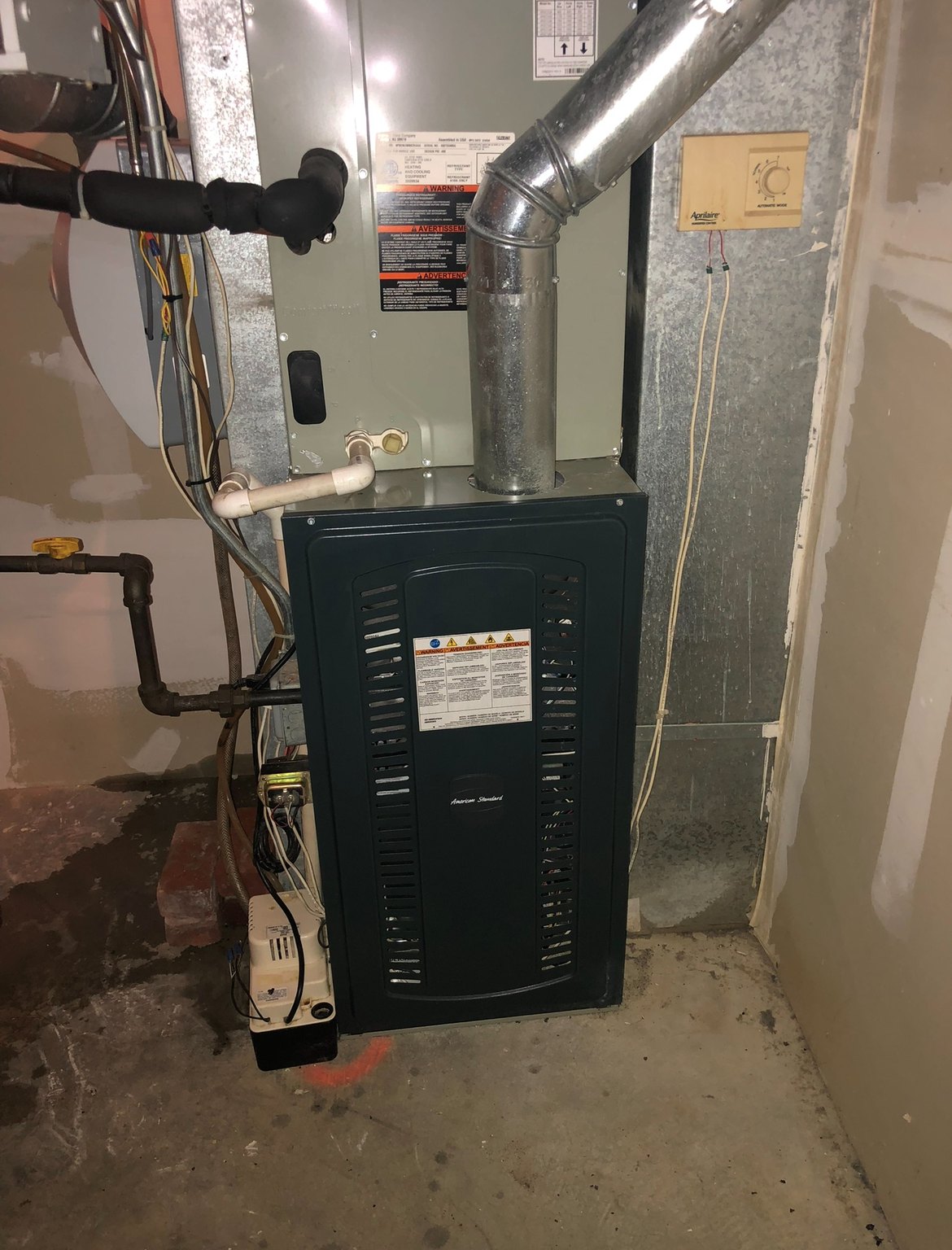 An air conditioner is sitting in the corner of a room.