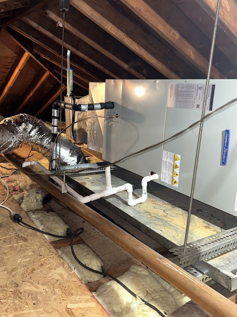 An air conditioner is being installed in the attic of a house.