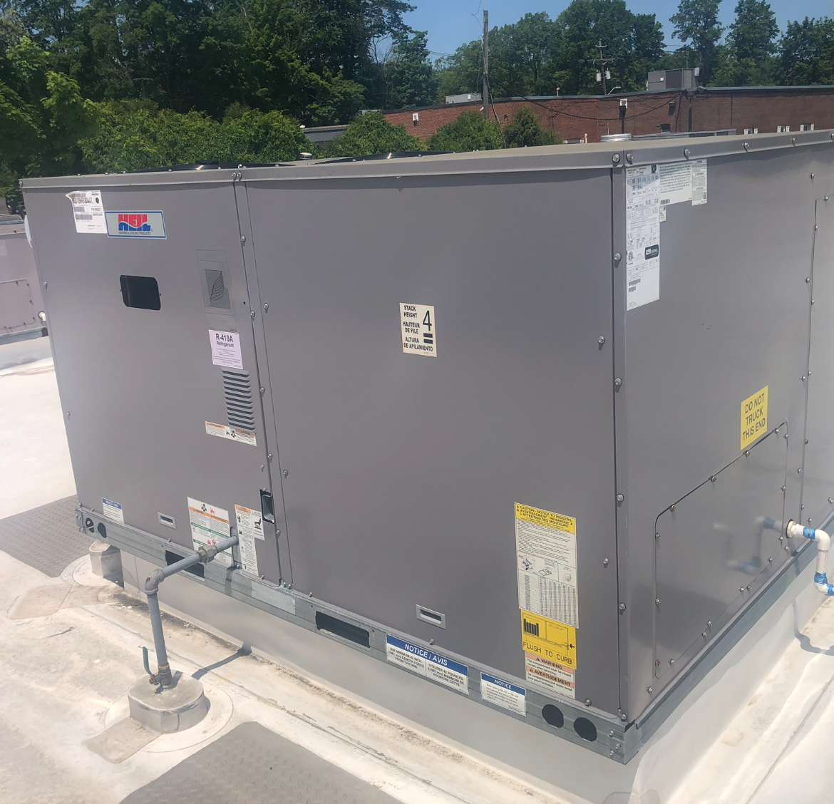 A large gray box is sitting on top of a white roof.