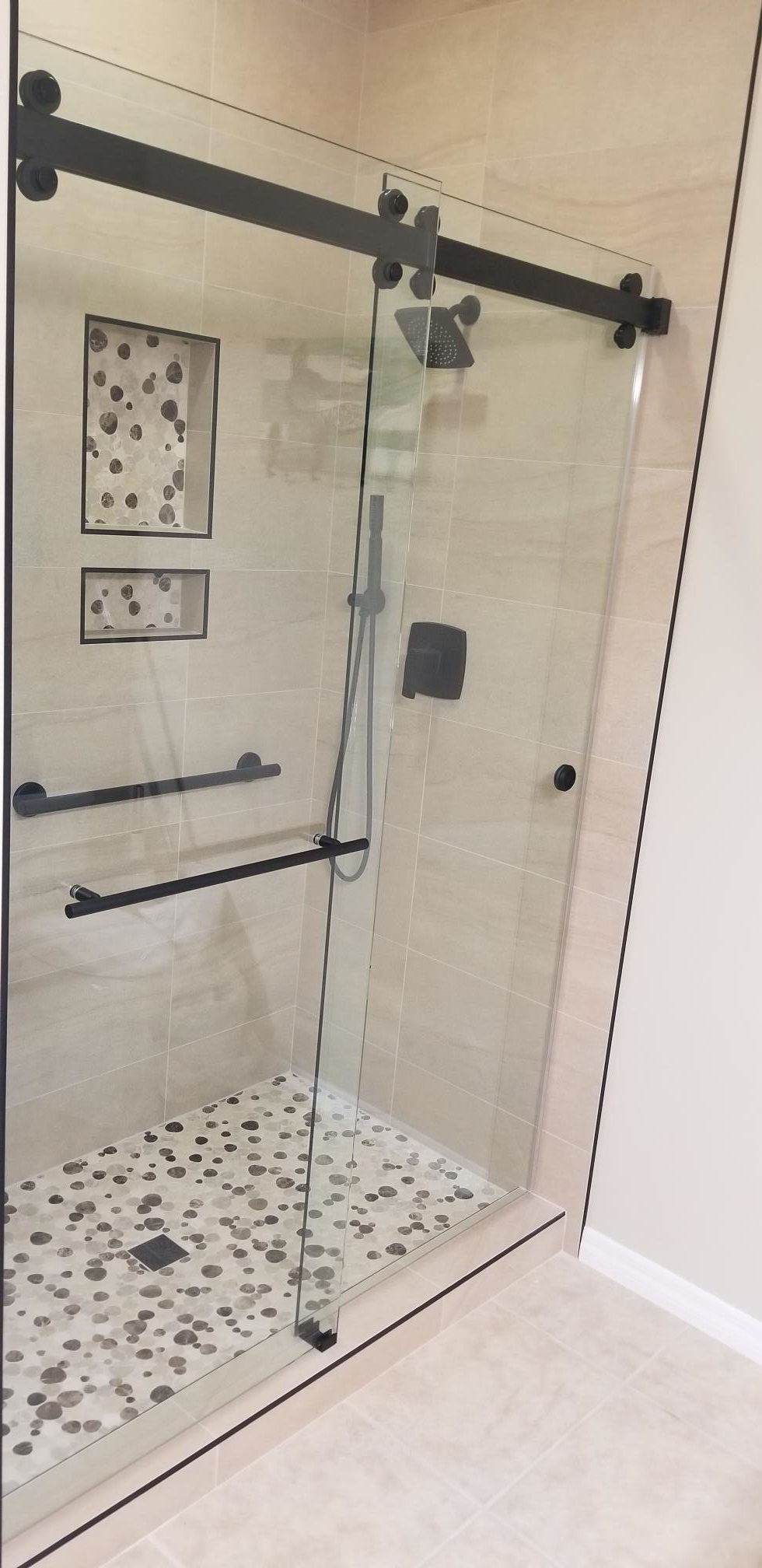 A bathroom with a sliding glass shower door.