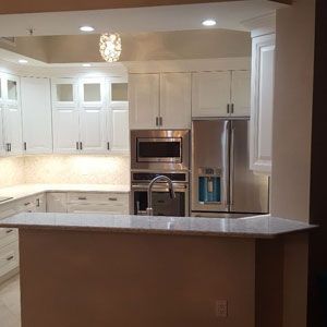 A kitchen with stainless steel appliances and white cabinets