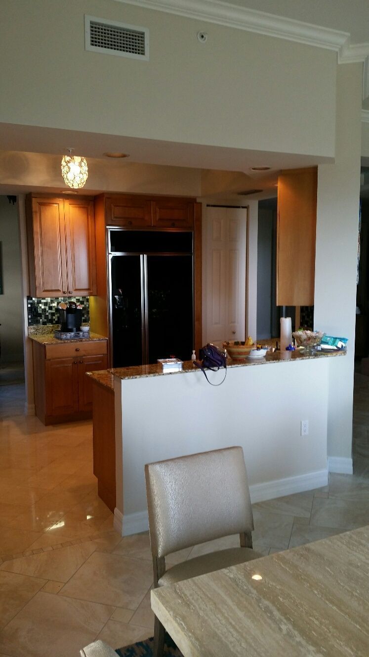 A kitchen with a table and chairs and a refrigerator