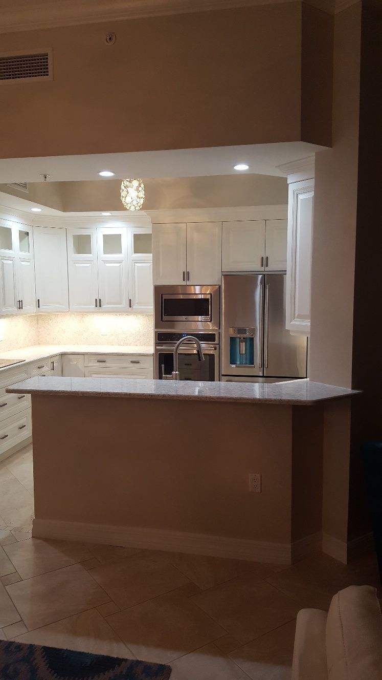 A kitchen with white cabinets and  stainless steel appliances