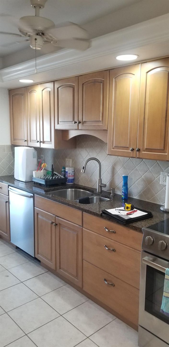 Kitchen with light-colored wooden cabinets, stainless steel appliances, and a dark countertop.