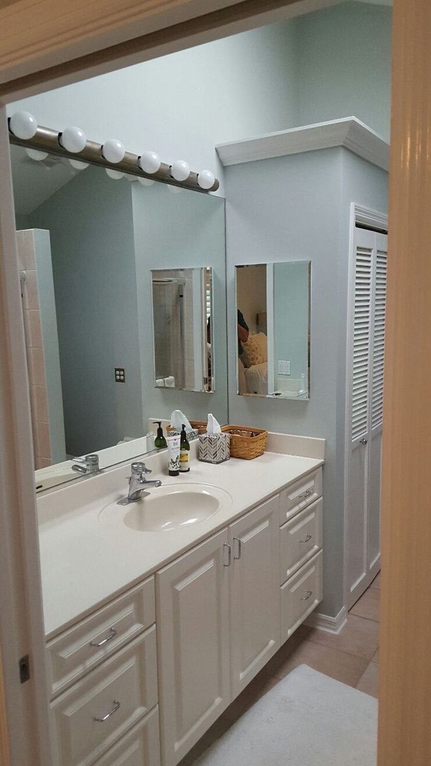 A bathroom with a sink, a mirror and a closet