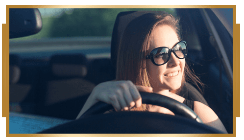 Beautiful businesswoman in sunglasses driving her car