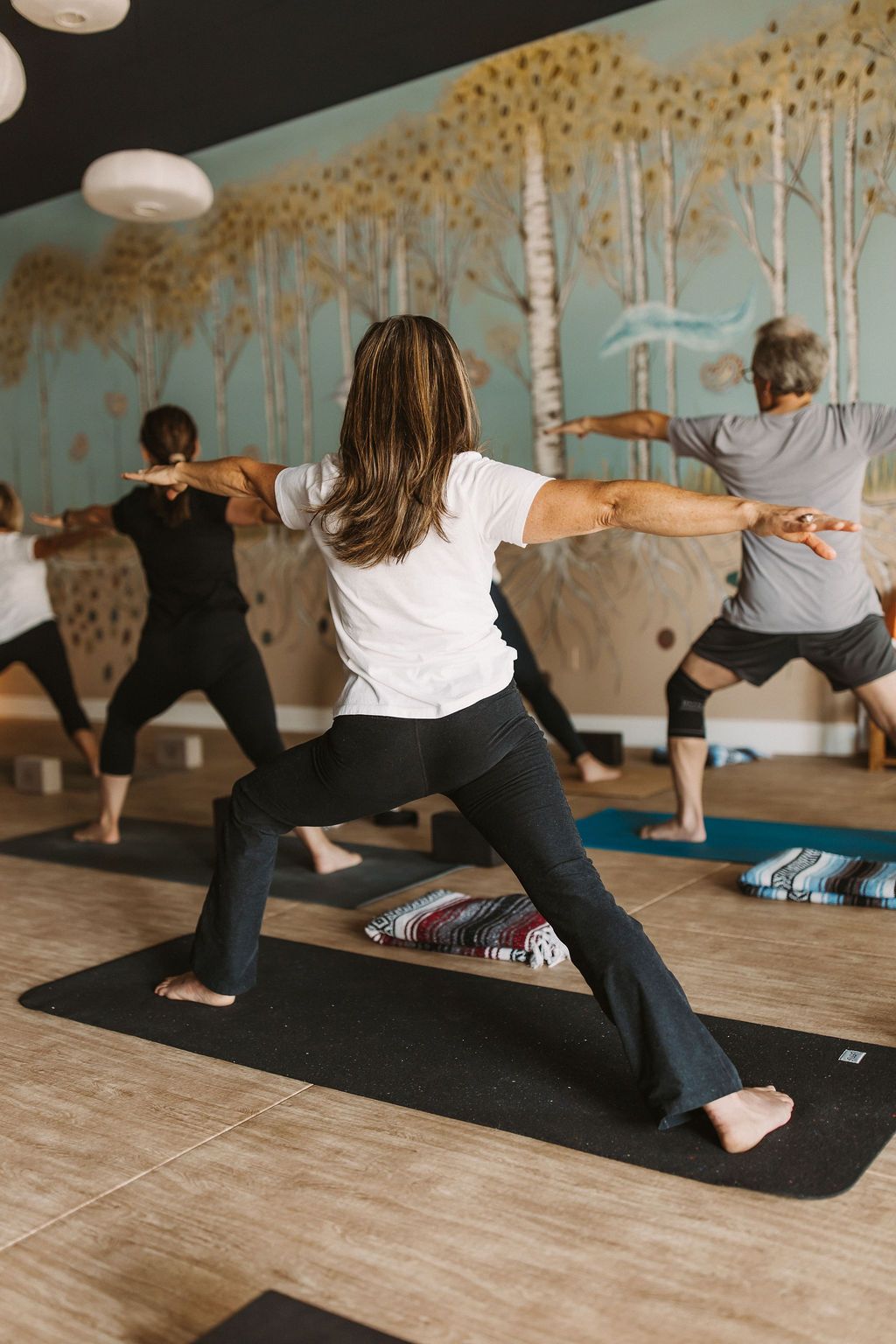 Class in warrior 2 from back angle