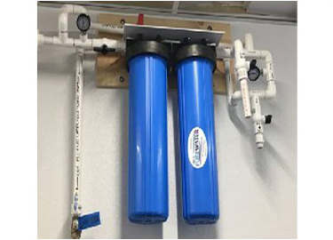 Two blue water filters are hanging on a wall.