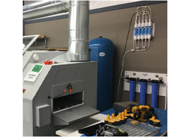 A machine is sitting in a room next to a blue tank.