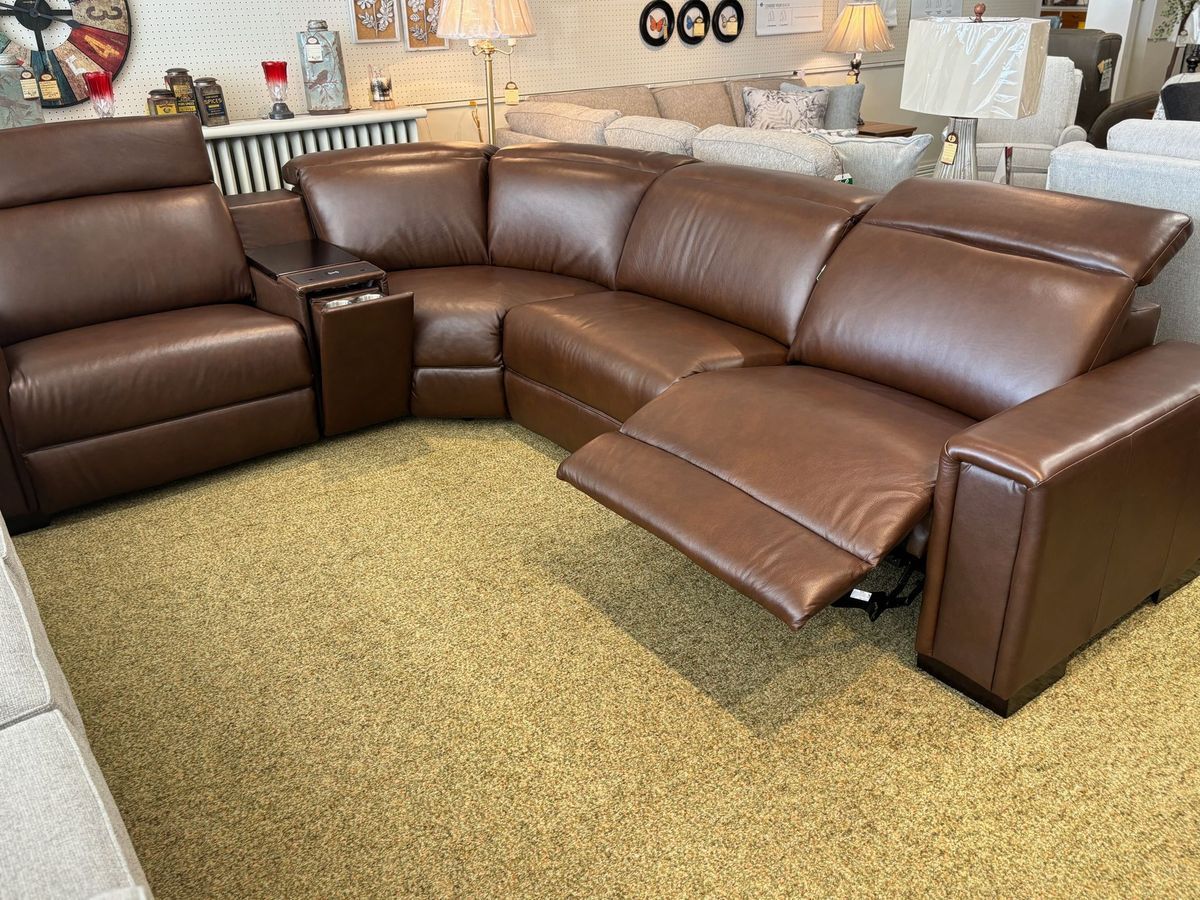 Brown leather reclining sectional sofa with a center console, on a beige carpet.