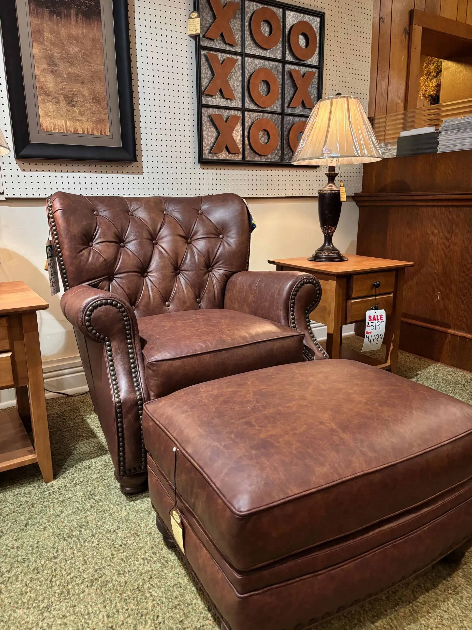 Brown leather armchair and ottoman set with a tufted back.
