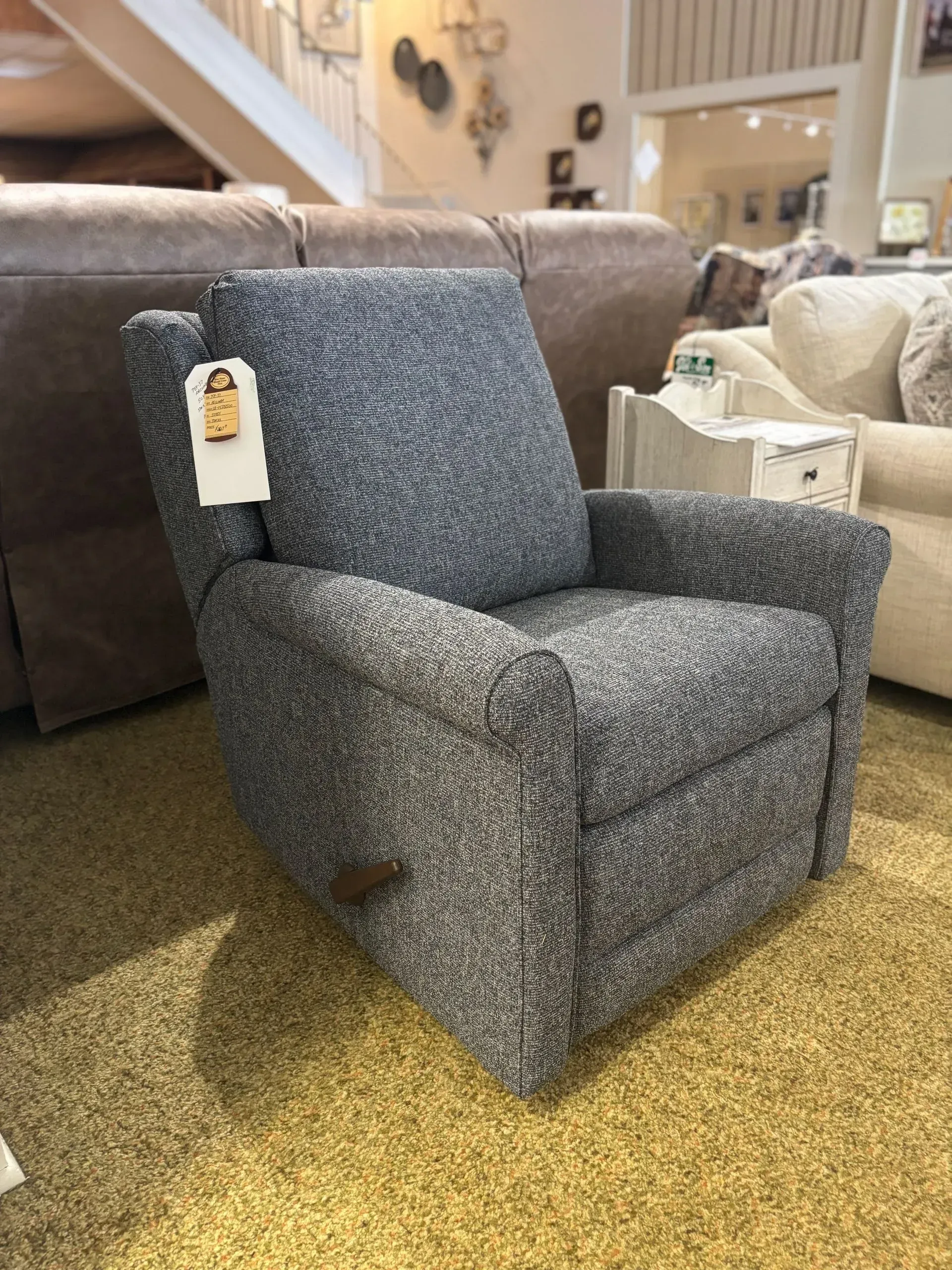 Blue speckled upholstered recliner chair in a furniture store.