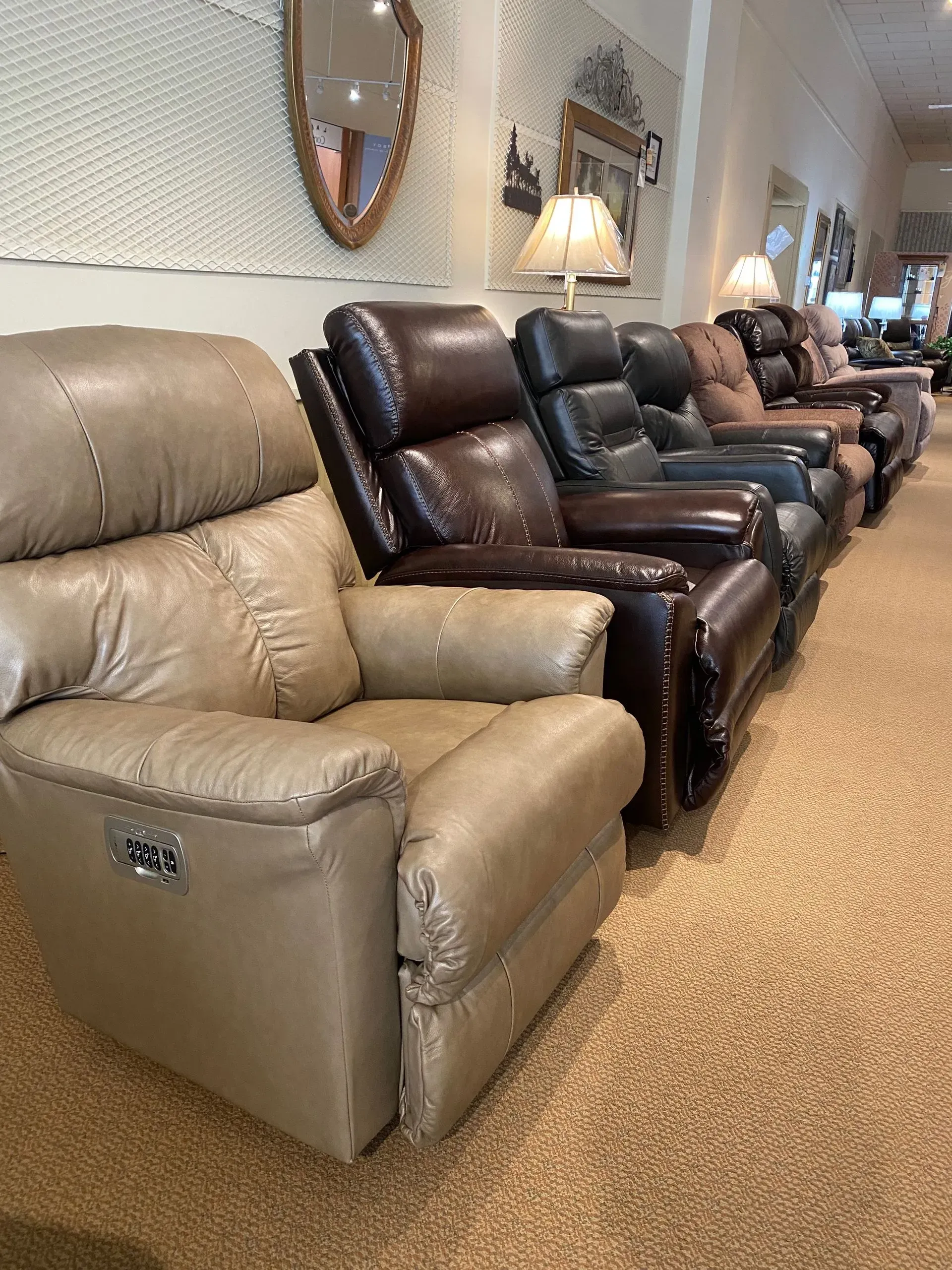 Row of leather recliners in varying shades, on display in a store.