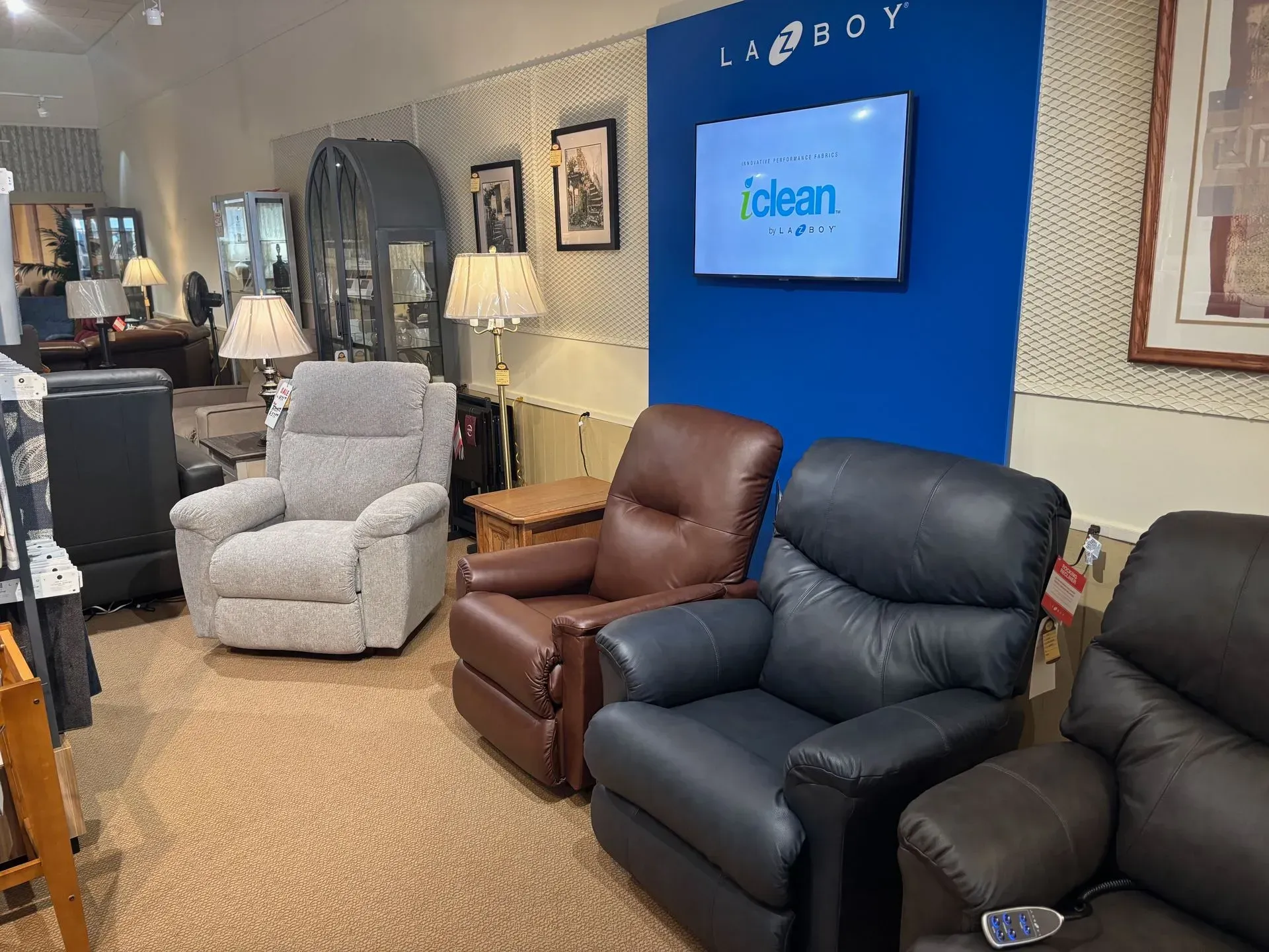 A furniture showroom displays recliners in various colors, including gray, brown, and black.